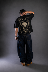 9ELIXIR Ikaros oversized tee — monochrome winged-figure line graphic on black cotton, front